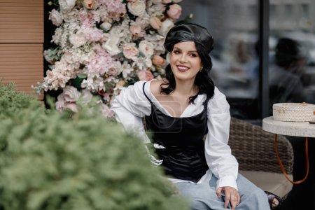 Foto de Beauty disabled french styled Woman with bionic prosthetic arm, artificial hand posing in spring flower interior cafe. Women diversity - Imagen libre de derechos