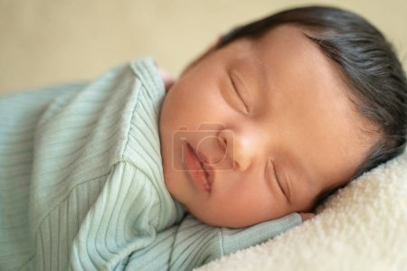 Foto de Bebé recién nacido con el pelo oscuro acostado en el lado durmiendo despertar los ojos abiertos. Lindo niño del Medio Oriente en manta. Tranquil escena de cerca - Imagen libre de derechos