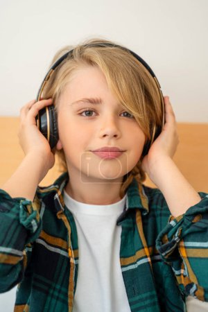 Téléchargez les photos : Adolescent utilisant un casque sans fil écouter de la musique, profiter de la vie, passe-temps, style de vie à la maison Vertical - en image libre de droit
