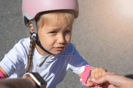 Téléchargez les photos : Mère enseignant à sa fille à patiner sur des patins à roues alignées dans un parc public en été. Loisirs en famille jeu d'activité sportive de plein air. Copier l'espace négatif - en image libre de droit