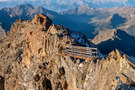 Téléchargez les photos : Petit pont en bois sur un sentier au-dessus d'une crête rocheuse exposée près de Rifugio Quintino Sella dans les Alpes italiennes - en image libre de droit
