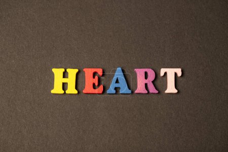 Foto de Composición de vista superior hecha de letras multicolores de signo del corazón sobre fondo marrón - Imagen libre de derechos