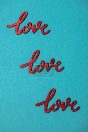 Foto de Top view composition of bright red Love signs placed in staggered rows on blue surface - Imagen libre de derechos