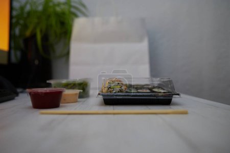 Foto de Side view of assorted sushi and rolls with soy sauce placed on wooden table - Imagen libre de derechos