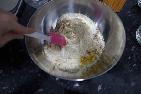 Foto de Anonymous person mixing a bowl with sugar, ground almonds, cinnamon and lemon zest. - Imagen libre de derechos