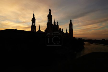 Foto de Silhouette of the basilica del pilar in a sunset next to the ebro river - Imagen libre de derechos