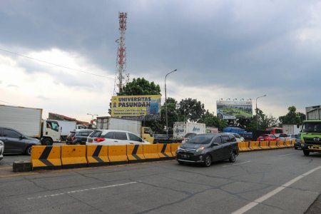 Foto de Bandung, Indonesia - 13 de abril de 2023: Los coches pasan por la puerta de peaje de Buah Batu con el cielo azul en el fondo. - Imagen libre de derechos