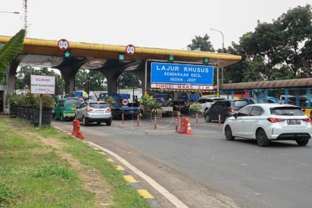 Foto de Bandung, Indonesia - 13 de abril de 2023: Los coches hacen cola en la puerta de peaje de Buah Batu con el cielo azul al fondo. - Imagen libre de derechos