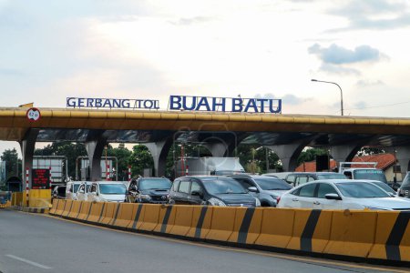 Foto de Bandung, Indonesia - 13 de abril de 2023: Los coches pasan por la puerta de peaje de Buah Batu con el cielo azul en el fondo. - Imagen libre de derechos
