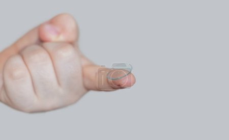 kid child little boy holding silicone contact lens on finger or trying to get out the lenses from case box.improve vision better with optical issue problem myopia.safety wearing isolated on beige back