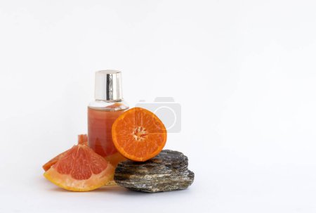 Photo for Small shower gel or shampoo bottle with golden color liquid isolated with grapefruit and tangerine half fruits slice on solid rock stone.product in soap holder with shower exfoliating sponge orange - Royalty Free Image