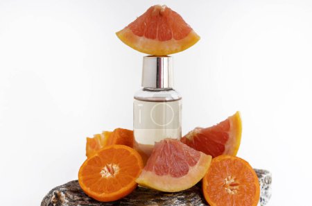 Photo for Small shower gel or shampoo bottle with golden color liquid isolated with grapefruit and tangerine half fruits slice on solid rock stone.product in soap holder with shower exfoliating sponge orange - Royalty Free Image