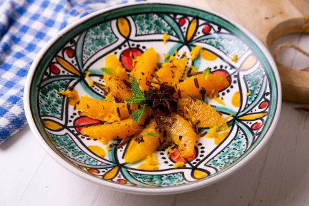 Foto de Spiced oranges with cloves and cinnamon served with organic honey and grated chocolate. - Imagen libre de derechos