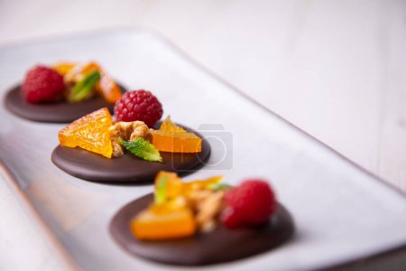 Téléchargez les photos : Dessert au chocolat à l'orange confite, framboise et noix. - en image libre de droit