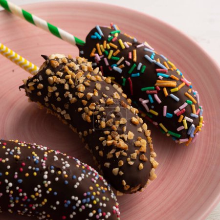 Téléchargez les photos : Bananes trempées dans du chocolat noir et recouvertes de caramel décoratif. - en image libre de droit