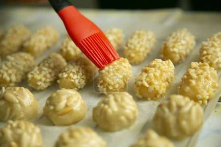 Foto de Penellets. Small sweets of various shapes, made from almond and potato dough, and covered with almonds or pine nuts. - Imagen libre de derechos