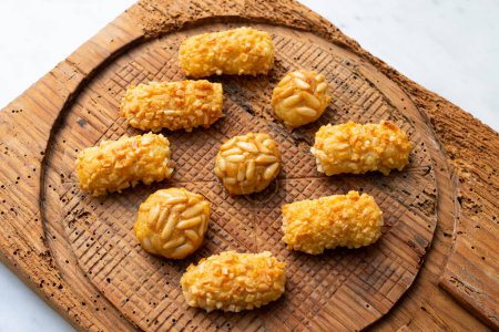 Photo for Penellets. Small sweets of various shapes, made from almond and potato dough, and covered with almonds or pine nuts. - Royalty Free Image