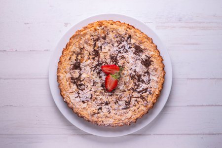 Foto de Almond cake with chocolate shavings and strawberry pieces. - Imagen libre de derechos