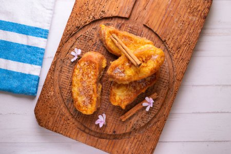 Photo for The torrija or torreja, also called French toast, is a dish made from a slice of bread that is soaked in milk, syrup or wine and, after being coated in egg, is fried in a pan with oil. - Royalty Free Image