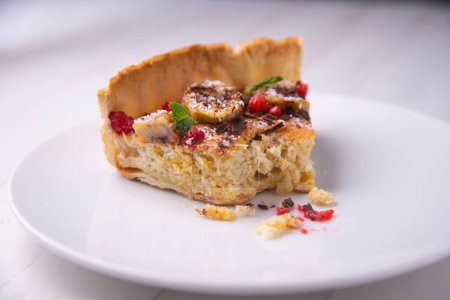 Photo for Banana yoghurt sponge cake with pieces of fresh fruit and chocolate on top - Royalty Free Image