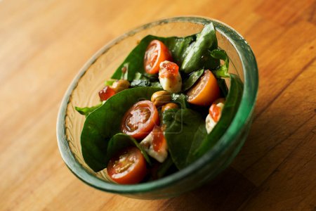 Photo for Small bowl of spinach salad with cherry tomatoes. - Royalty Free Image