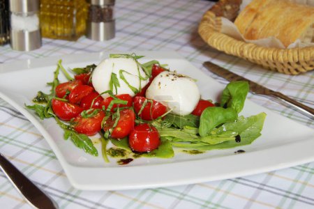 Photo for Burrata salad. The burrata is a fresh cow's milk cheese, with spun paste and round in shape, with an external appearance similar to that of mozzarella in the shape of a bag with the characteristic apical closure. - Royalty Free Image
