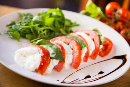 Photo for Caprese salad is an Italian salad made up of sliced tomatoes and fresh mozzarella, and fresh basil leaves. - Royalty Free Image