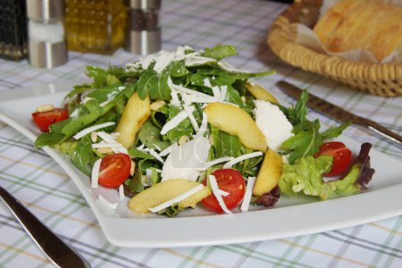 Foto de Deliciosa ensalada verde italiana con pera, mozzarella y tomates. - Imagen libre de derechos