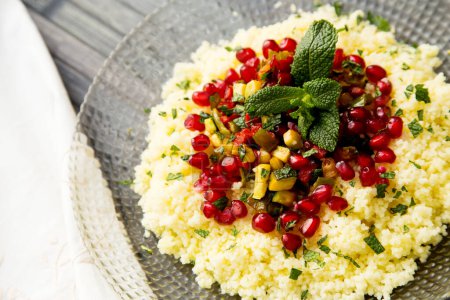 Photo for Couscous salad with pomegranate and mint leaves. - Royalty Free Image