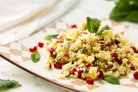 Photo for Couscous salad with pomegranate and mint leaves. - Royalty Free Image