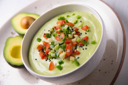 Photo for Avocado Gazpacho is a cold soup with various ingredients such as olive oil, vinegar, water, raw vegetables, usually tomatoes, cucumbers, peppers, and garlic. - Royalty Free Image