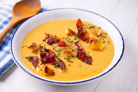 Photo for Bowl with carrot cream and iberico spanish ham. - Royalty Free Image