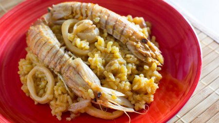 Foto de Paella tradicional española con mariscos como camarones rojos, mejillones, calamares. - Imagen libre de derechos