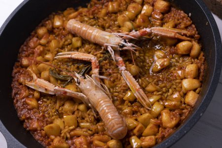 Photo for Traditional Spanish paella with seafood such as red shrimp, mussels, baby squid. - Royalty Free Image