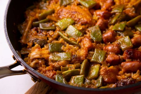 Téléchargez les photos : Paella traditionnelle espagnole aux saucisses, haricots verts et artichauts. - en image libre de droit