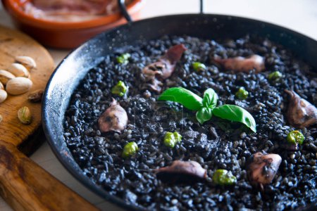 Photo for Traditional Spanish black paella with seafood made with squid ink. - Royalty Free Image