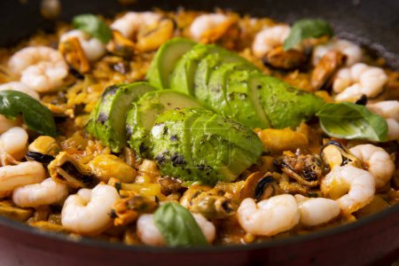 Photo for Traditional Spanish paella with shrimps and avocado. - Royalty Free Image