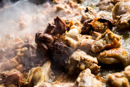 Téléchargez les photos : Préparation de la paella traditionnelle espagnole dans la ville de Valence. Ingrédients poulet, lapin, haricots, tomate, safran, ail et riz. - en image libre de droit