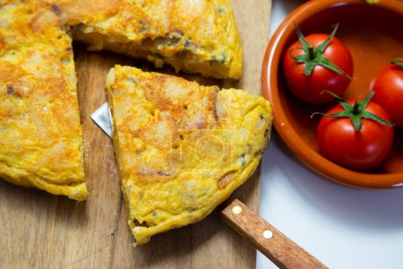 Photo for The potato omelette or Spanish omelette is an omelette or omelet to which chopped potatoes are added. It is one of the most well-known and emblematic dishes of Spanish cuisine. - Royalty Free Image
