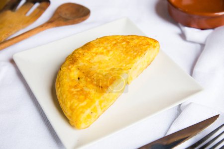 Photo for Spanish omelette with cod is an omelette or omelet to which chopped potatoes are added. It is one of the best-known and most emblematic dishes of Spanish cuisine - Royalty Free Image