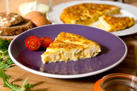 Photo for Spanish omelette with cod is an omelette or omelet to which chopped potatoes are added. It is one of the best-known and most emblematic dishes of Spanish cuisine - Royalty Free Image