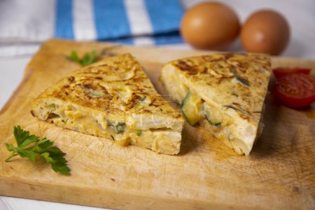 Photo for Spanish omelette with zucchini is an omelette to which chopped potatoes are added. It is one of the best-known and most emblematic dishes of Spanish cuisine - Royalty Free Image