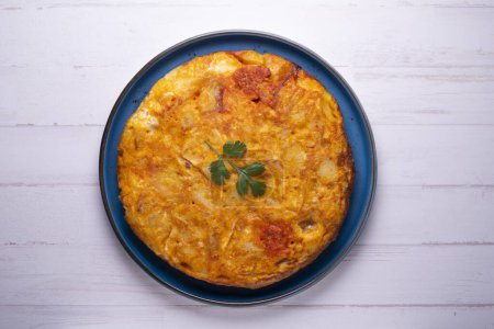 Photo for Spanish omelette with chorizo is an omelette to which chopped potatoes are added. It is one of the best-known and most emblematic dishes of Spanish cuisine - Royalty Free Image