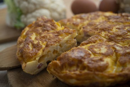 Photo for Spanish omelette with cauliflower is an omelette to which chopped potatoes are added. It is one of the best-known and most emblematic dishes of Spanish cuisine - Royalty Free Image