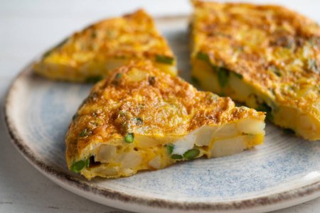 Téléchargez les photos : L'omelette espagnole aux asperges vertes est une omelette à laquelle sont ajoutées des pommes de terre hachées. C'est l'un des plats les plus connus et les plus emblématiques de la cuisine espagnole - en image libre de droit