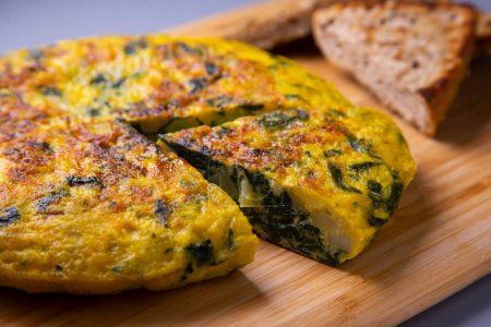 Téléchargez les photos : L'omelette espagnole aux épinards verts est une omelette à laquelle sont ajoutées des pommes de terre hachées. C'est l'un des plats les plus connus et les plus emblématiques de la cuisine espagnole - en image libre de droit