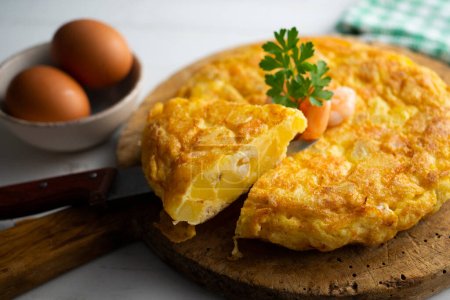 Photo for Spanish omelette with  prawns is an omelette to which chopped potatoes are added. It is one of the best-known and most emblematic dishes of Spanish cuisine - Royalty Free Image