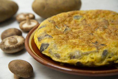 Photo for Spanish omelette with Japanese shitake mushrooms is an omelette to which chopped potatoes are added. It is one of the best-known and most emblematic dishes of Spanish cuisine - Royalty Free Image