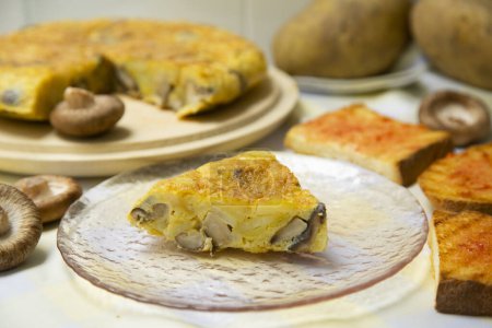 Téléchargez les photos : L'omelette espagnole aux champignons chitake japonais est une omelette à laquelle sont ajoutées des pommes de terre hachées. C'est l'un des plats les plus connus et les plus emblématiques de la cuisine espagnole - en image libre de droit
