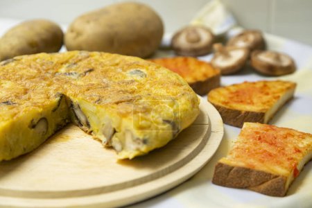 Téléchargez les photos : L'omelette espagnole aux champignons chitake japonais est une omelette à laquelle sont ajoutées des pommes de terre hachées. C'est l'un des plats les plus connus et les plus emblématiques de la cuisine espagnole - en image libre de droit
